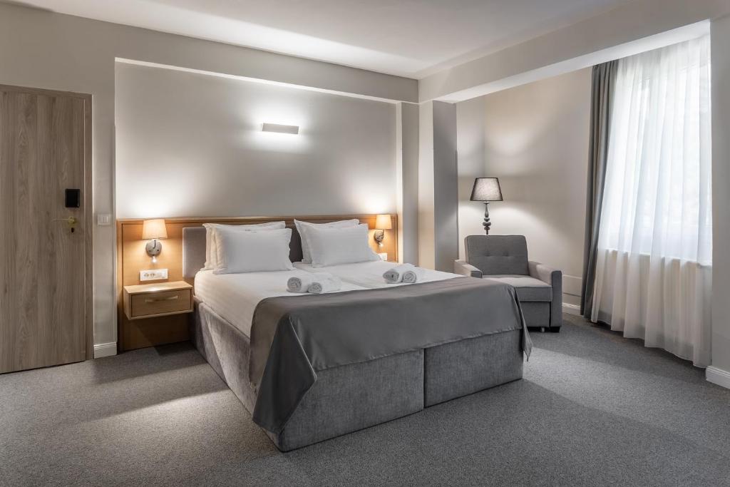 a hotel room with a large bed and a chair at GENESIS by Eden in Predeal