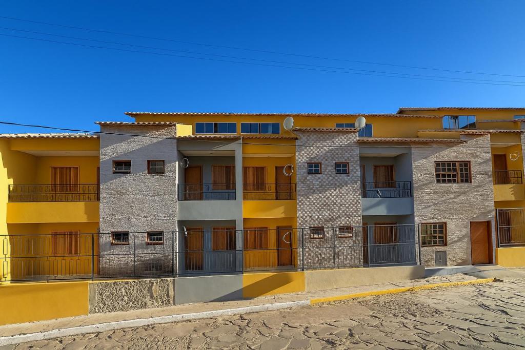 an apartment building with yellow and gray at Pousada Recanto das Estrelas in São Thomé das Letras