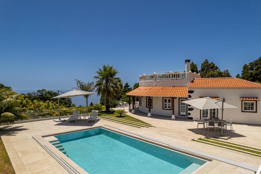 a villa with a swimming pool in front of a house at Casa Mi Arcadia in El Paso
