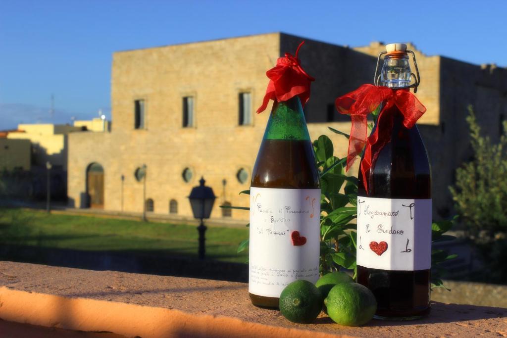 deux bouteilles de vin assises sur un livre avec des limes dans l'établissement Casa Dei Furnari, à Collepasso