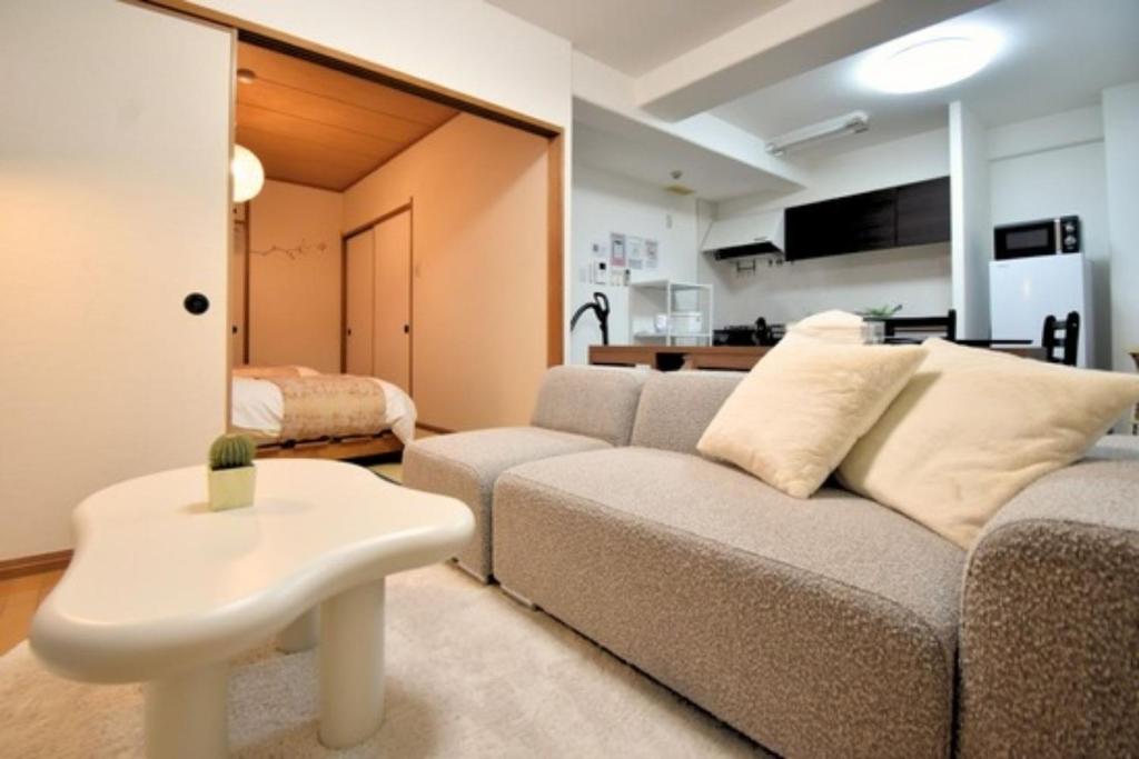 ein Wohnzimmer mit Sofa und Tisch in der Unterkunft Scarl Matsunawa / Vacation STAY 49770 in Takamatsu