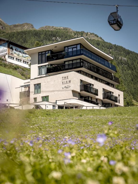 um edifício numa colina com flores à frente em The View by Regina em Sölden