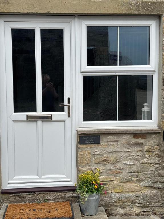 a person taking a picture of the door of a house at Swallow Cottage Middleham in Middleham