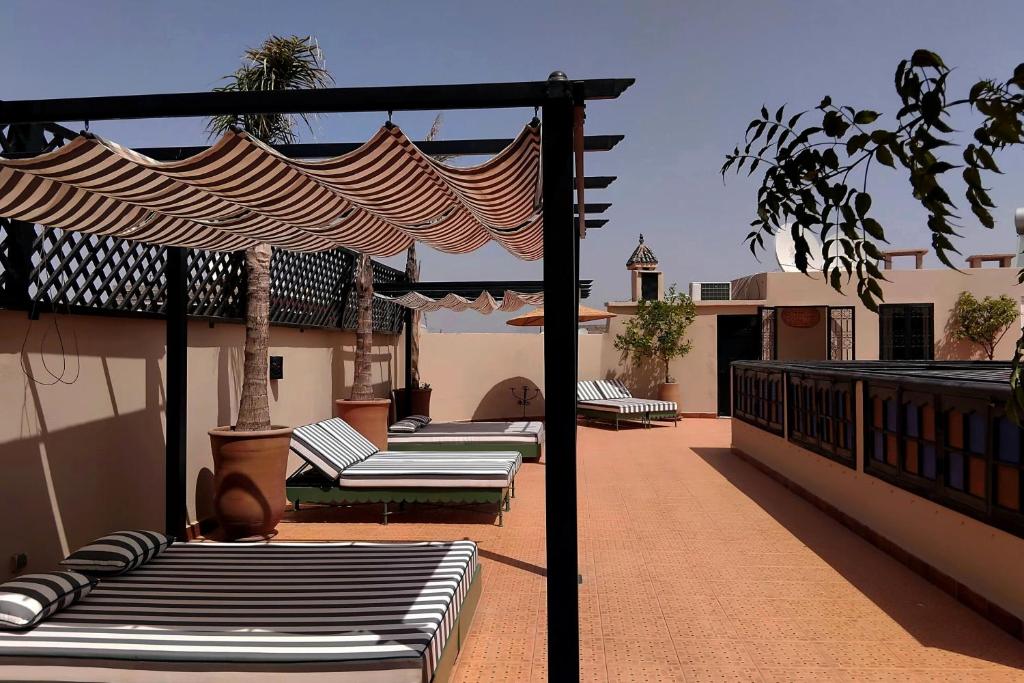 une rangée de chaises longues sur un patio dans l'établissement Riad Yakimour, à Marrakech