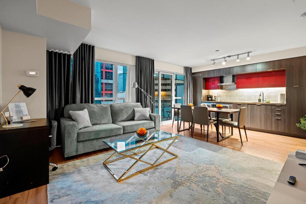 a living room with a couch and a table at Classy 1-Bedroom & Den Condo in Heart of Downtown in Toronto