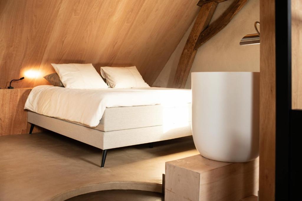 a bedroom with a bed and a table with a lamp at Boutique Suite Hotel Bolt21 Maastricht in Berg en Terblijt