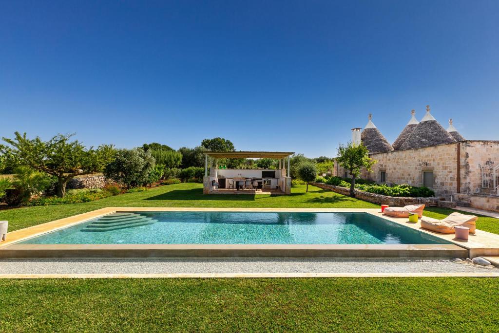 une piscine au milieu d'une cour dans l'établissement Trulli Almaviva by Perle di Puglia, à Cisternino