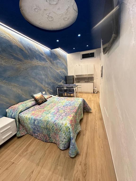a bedroom with a large bed with a painting on the wall at Starry Sky House in Mola di Bari