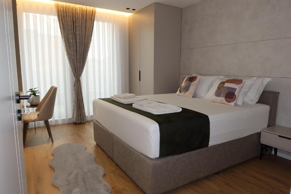 a bedroom with a large white bed and a desk at Hotel Ari Gjakove in Gjakove