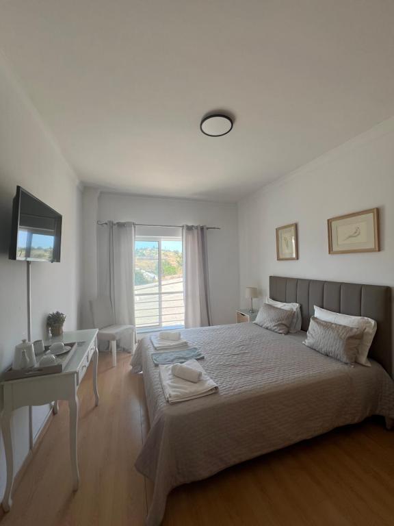 Un dormitorio con una cama y un escritorio y una ventana. en Lagos Royal Rooms and Suites, en Lagos