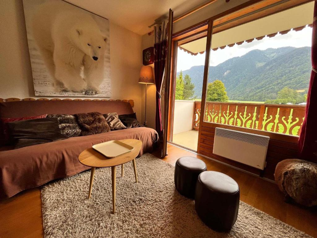 - une chambre avec un lit, une table et un balcon dans l'établissement Appartement T2 calme avec balcon, proche ski-bus et village - FR-1-624-37, à Samoëns