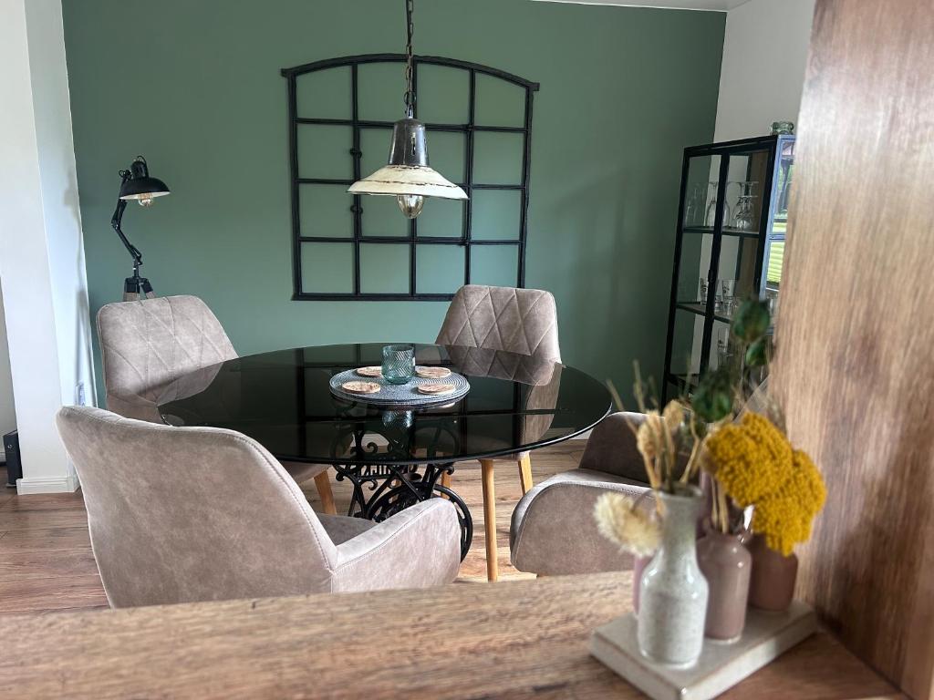 a dining room with a glass table and chairs at Ferienhaus Glückszeit bei Goslar in Langelsheim