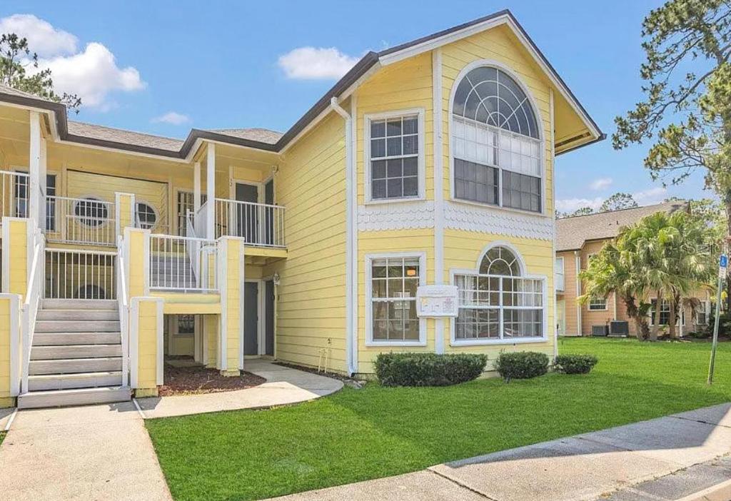a large yellow house with a yard at Family Fun Getaway close to Disney in Kissimmee