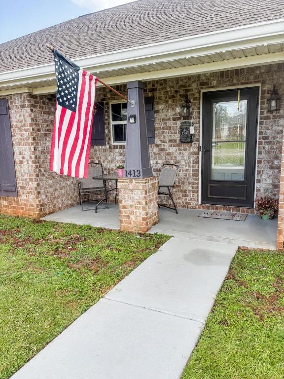 ein Haus mit einer amerikanischen Flagge auf der Veranda in der Unterkunft FUNshine Cottage! in Foley