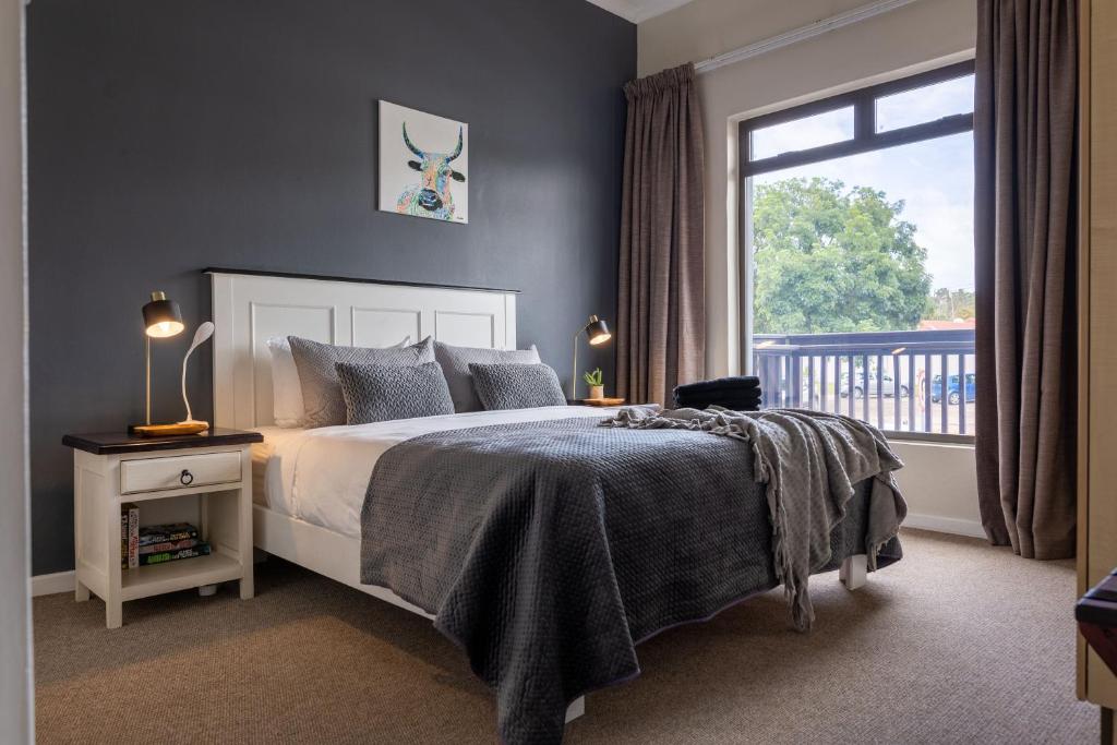 a bedroom with a bed and a large window at Plett Escape - Central & Walk to the Beach in Plettenberg Bay