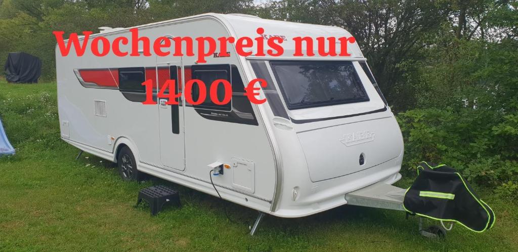 a white caravan with a sign on the side of it at Wohnwagen am See in Nordhausen