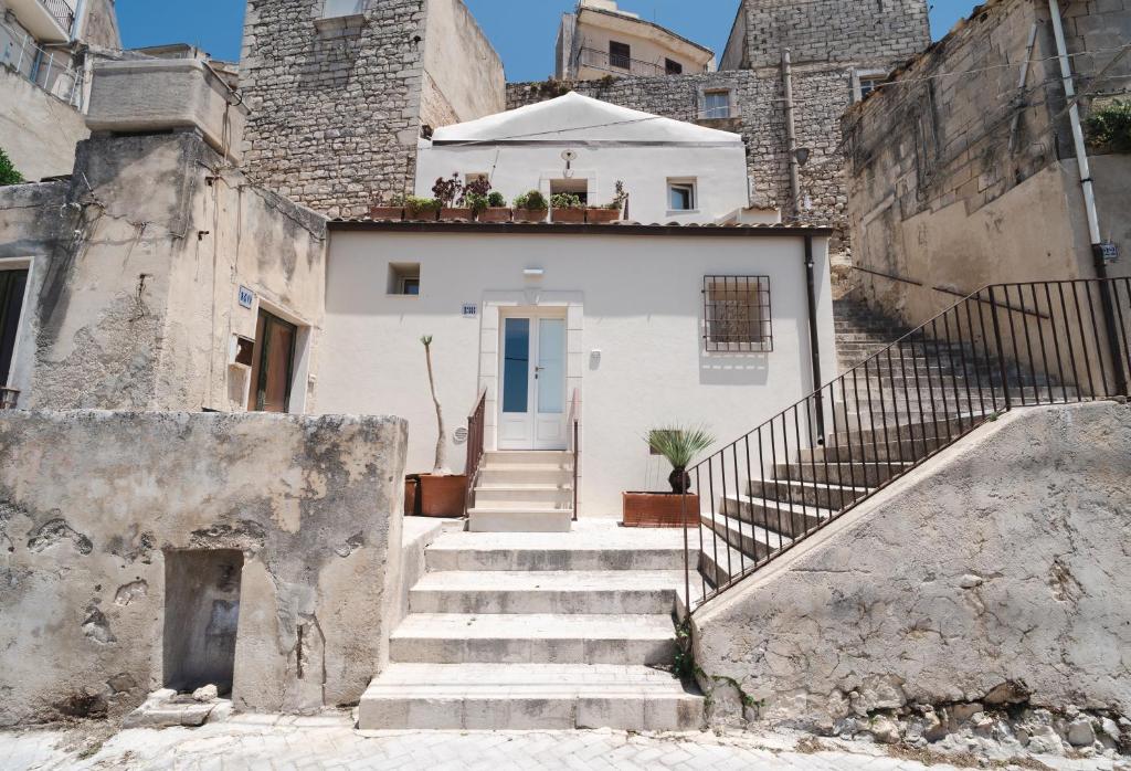 a house with stairs leading up to a blue door at Casa Cucunci in Modica