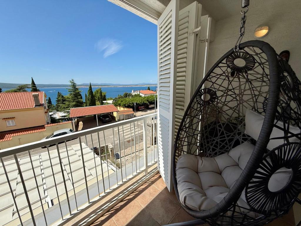 a swing on a balcony with a view of the ocean at Apartman Val in Dramalj