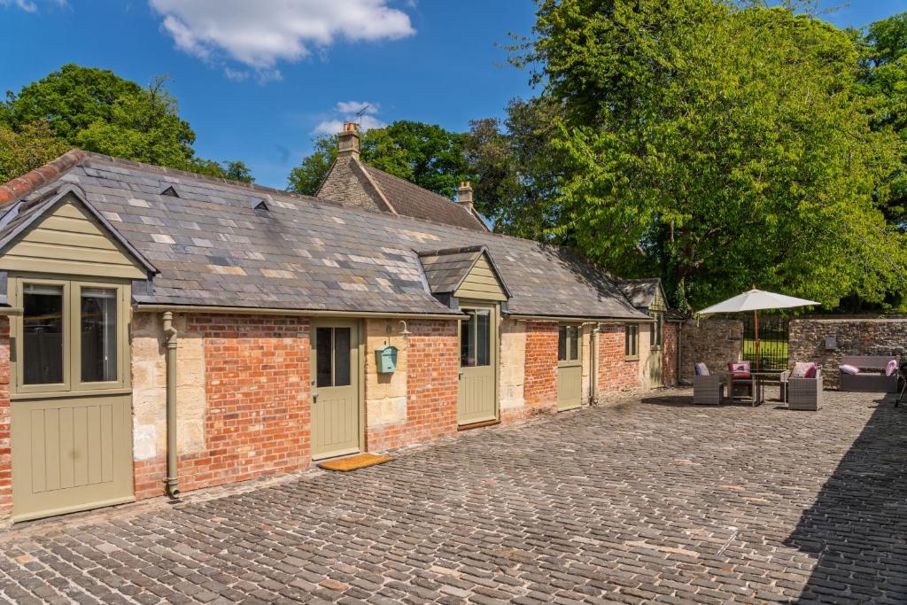 a row of buildings on a brick road at Home Farm Byre in Tormarton