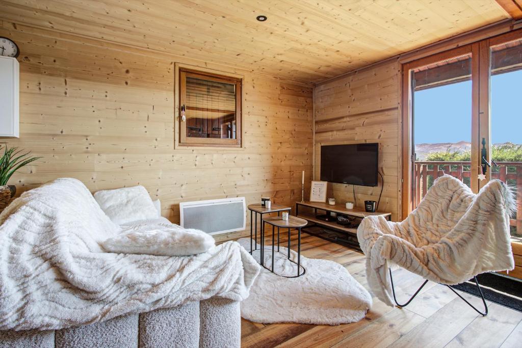 a living room with a couch and a tv at Chalet Sophie - Proche station de ski in Les Angles