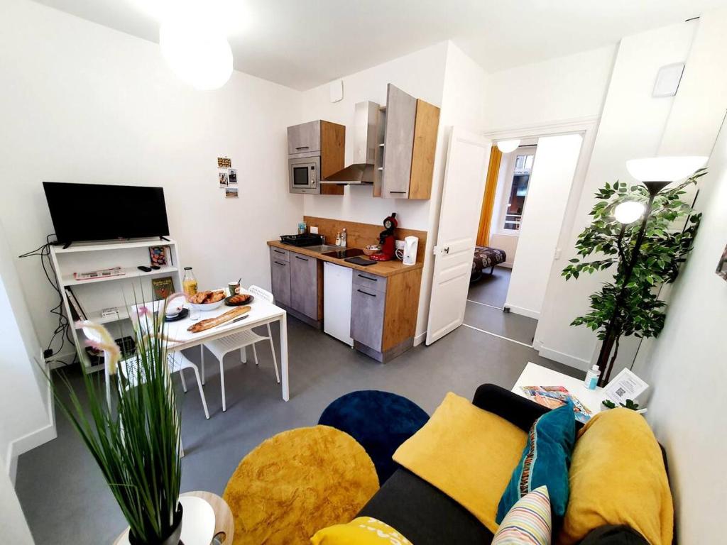 un soggiorno con divano e cucina di Le binic - proche gare et centre a Saint-Brieuc