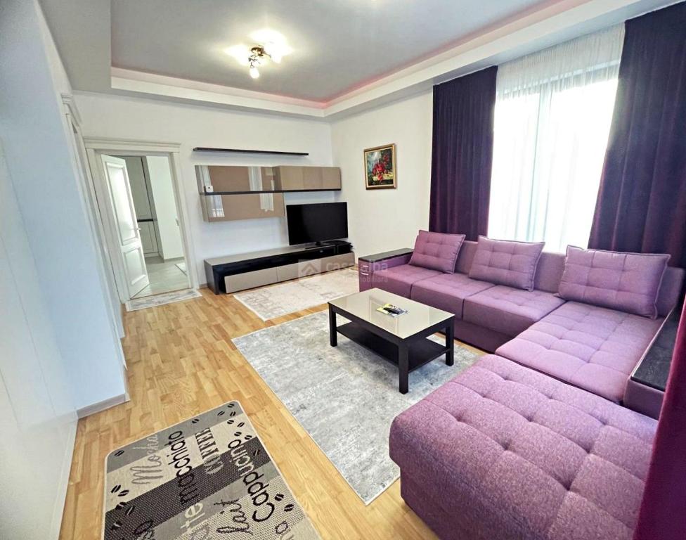 a living room with a purple couch and a table at Vila Premium Iasi in Iaşi