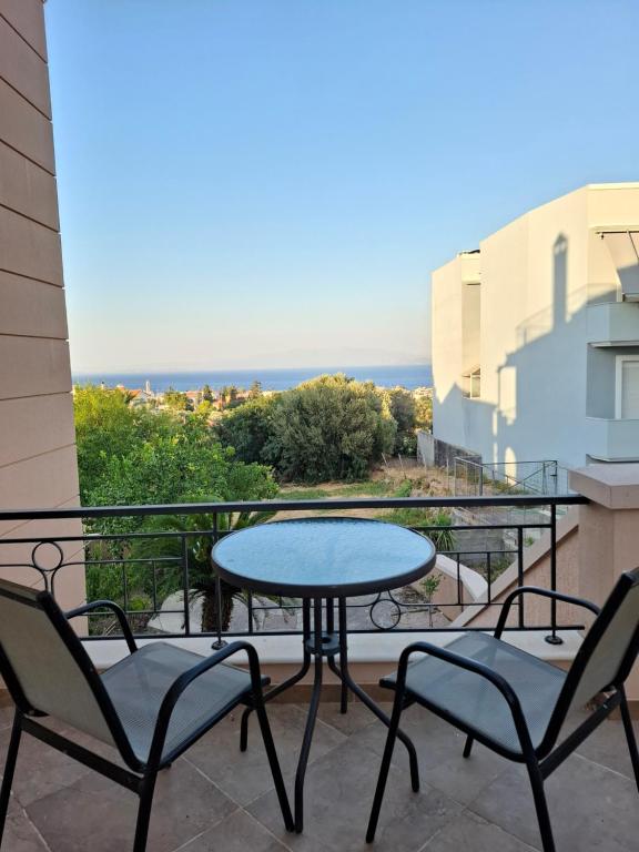 um pátio com 2 cadeiras e uma mesa na varanda em Helen's Eden em Quios