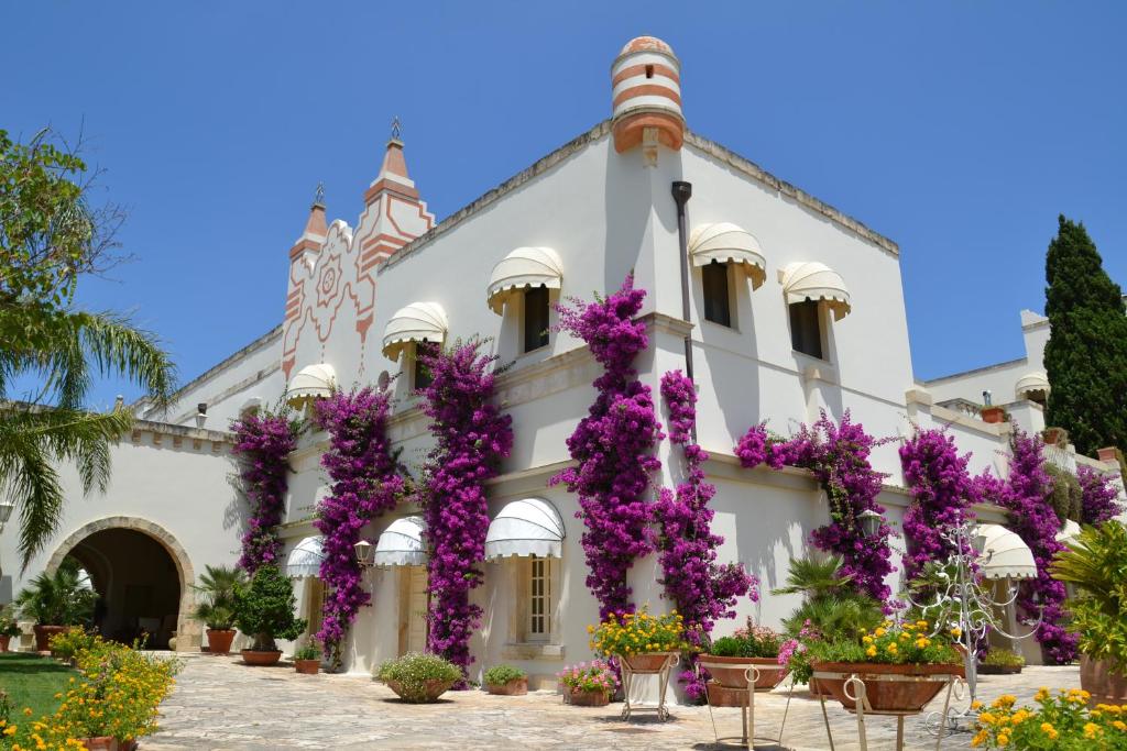 a building with purple flowers in front of it at Sangiorgio Resort & Spa in Cutrofiano