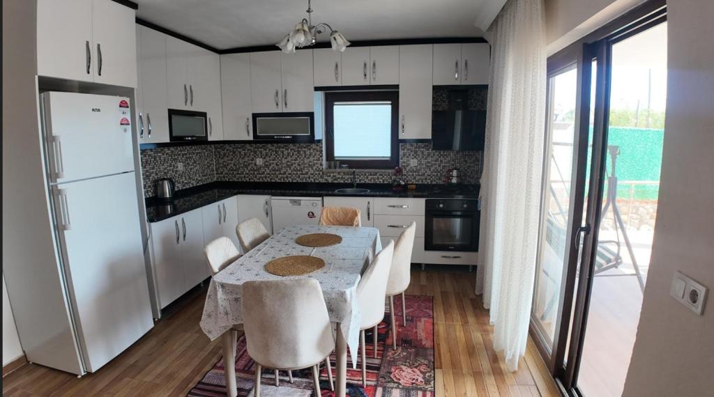 a kitchen with a table and chairs and a refrigerator at Köyceğiz Sığla Villa in Muğla