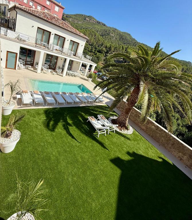 a shadow of a man standing next to a palm tree at Villa Raquel Montanejos in Montanejos