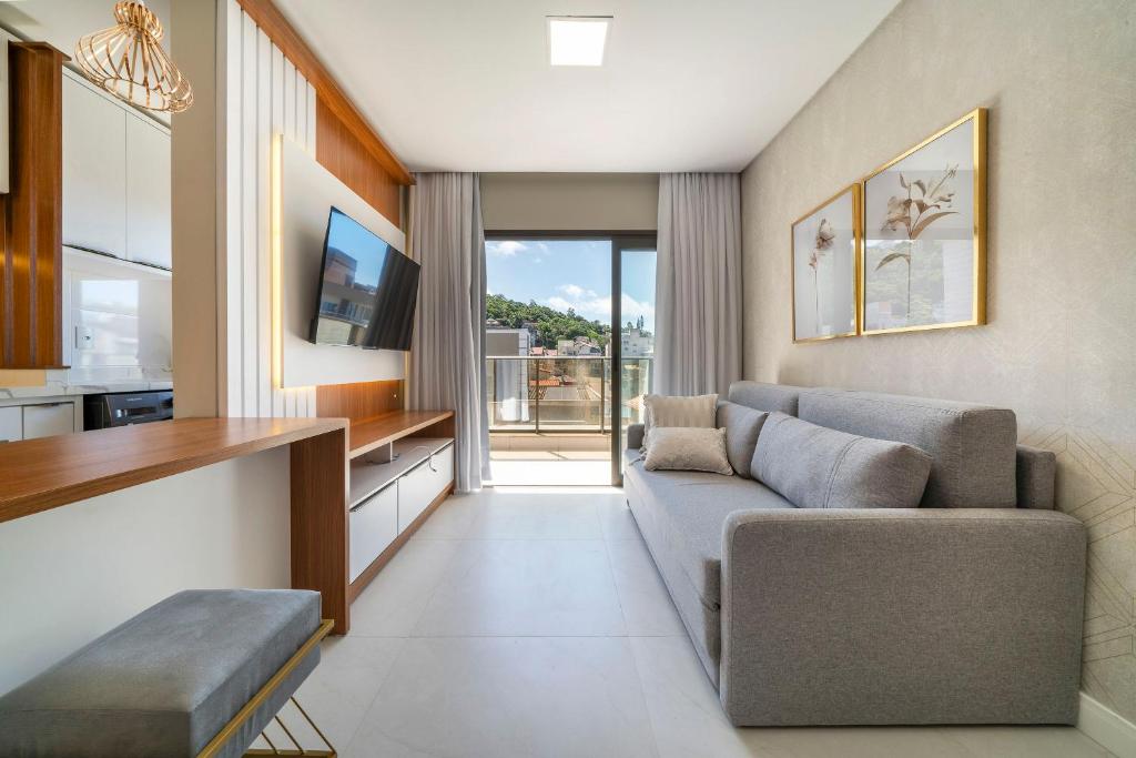 Sunrise Residence في بومبينهاس: غرفة معيشة مع أريكة وتلفزيون