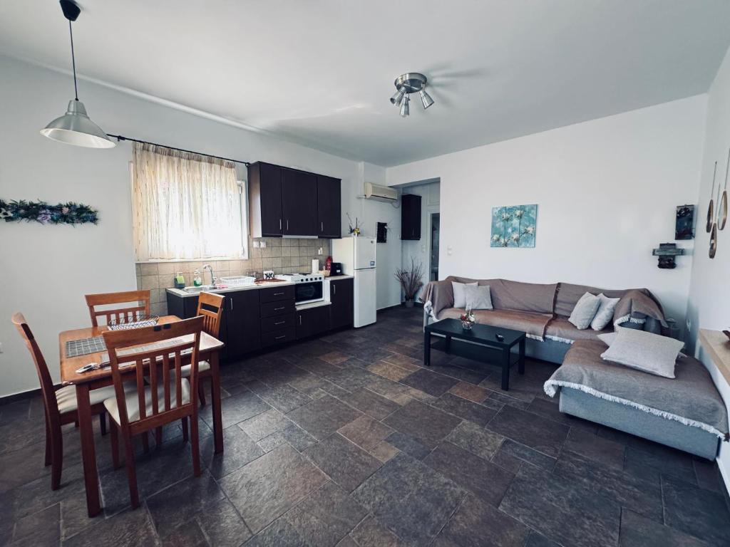 un soggiorno con un divano e un tavolo di Portolos Apartments - Filiatro a Vathi