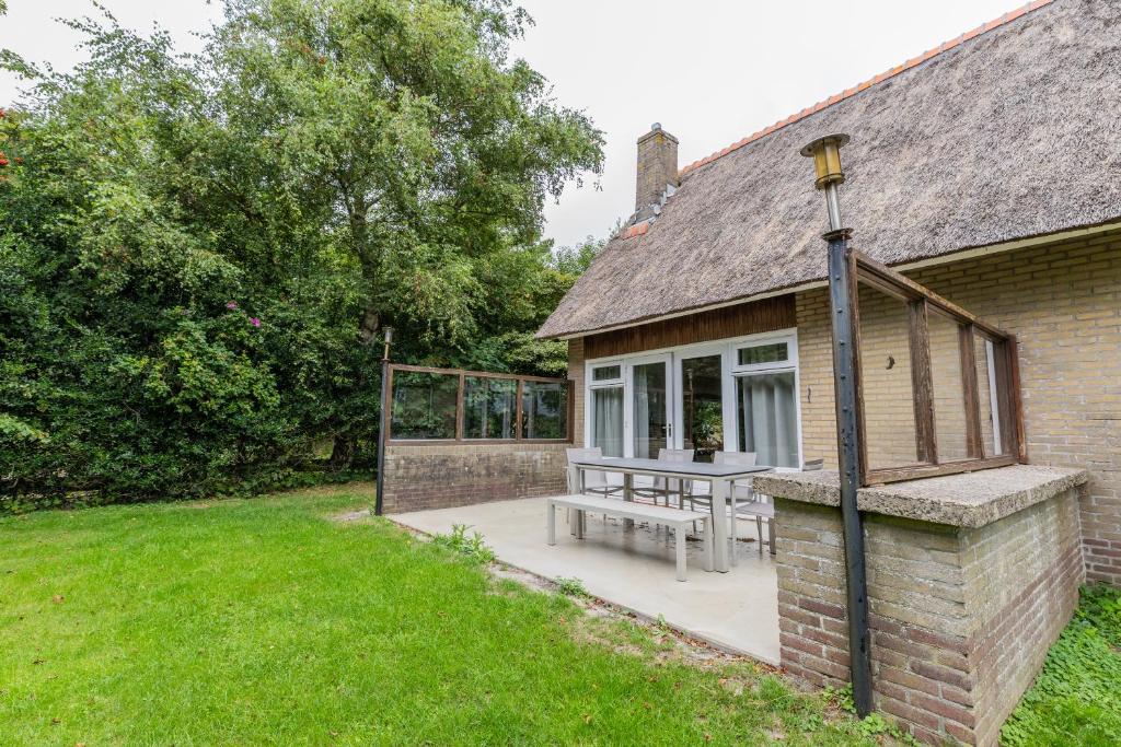 una casa con una mesa de picnic fuera de ella en Strandbloem, en Hollum