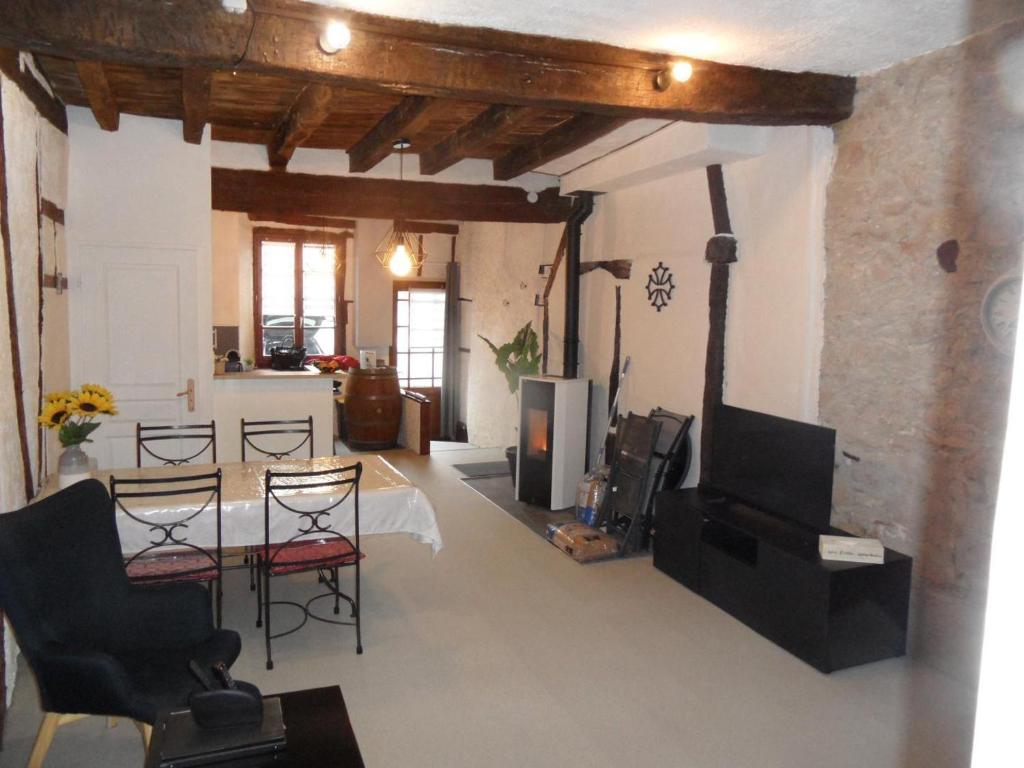 a living room with chairs and a table and a television at Escapade lauragaise in Saint-Félix-Lauragais