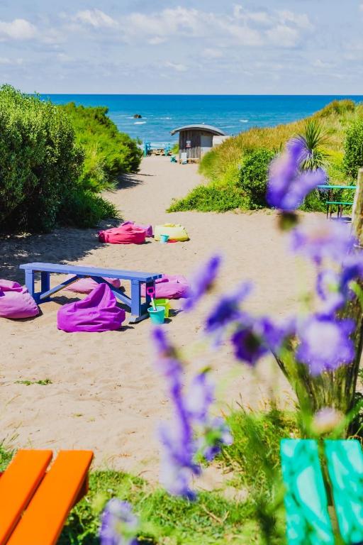 a picnic table on the beach with purple flowers at Beach House in Bude