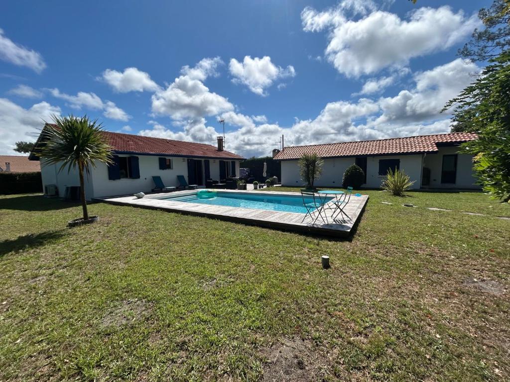 une maison avec une piscine dans une cour dans l'établissement Maison familiale avec piscine, à La Teste-de-Buch