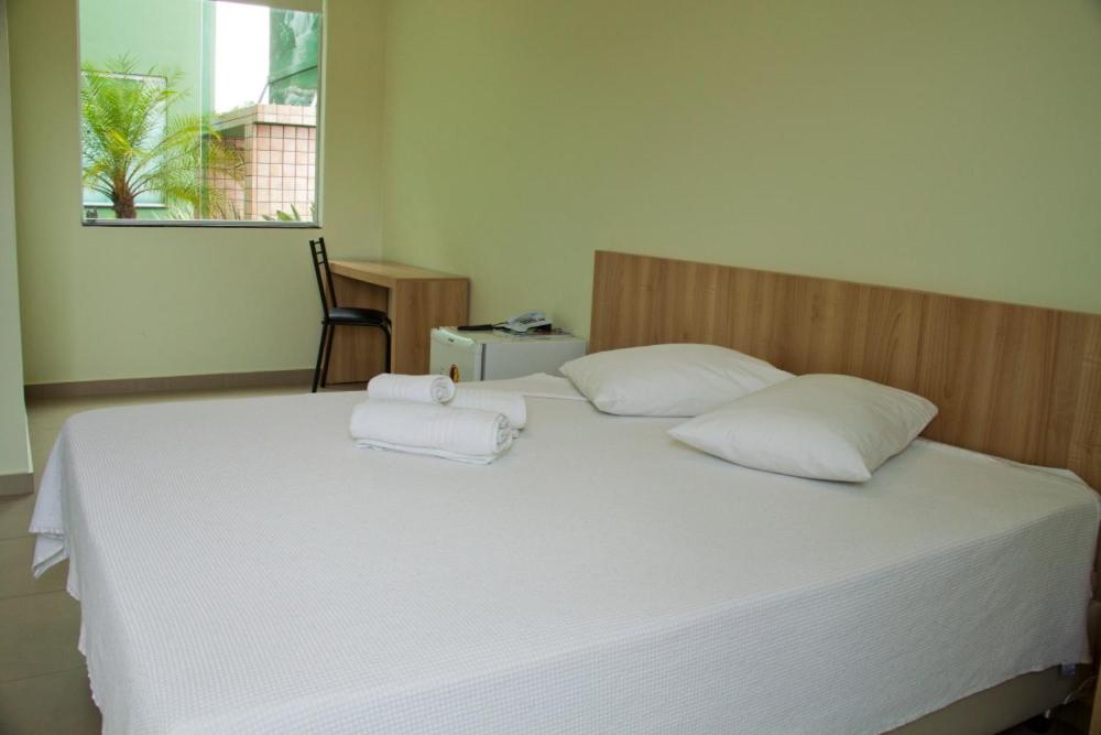 a large bed with two white pillows on it at HC Hotel Paraopeba in Paraopeba