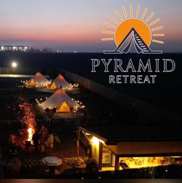 a sign for a pyramid retreat with tents at night at Pyramid Retreat in Sebeş