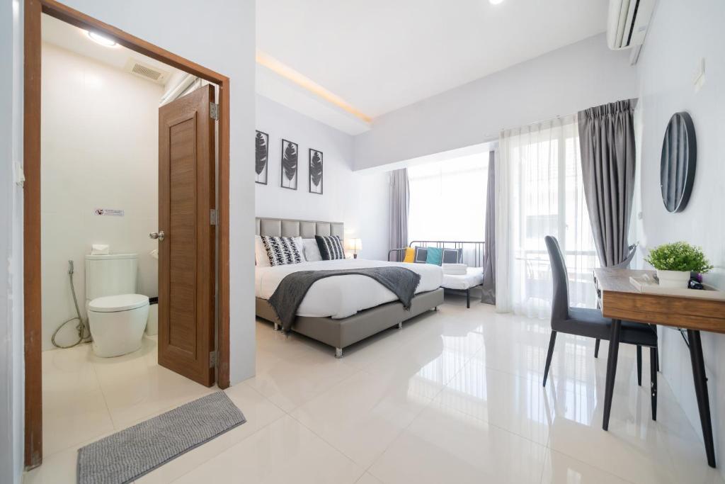 ein Schlafzimmer mit einem Bett, einem Tisch und einem Schreibtisch in der Unterkunft Reach Patong beach in one minute in Patong Beach