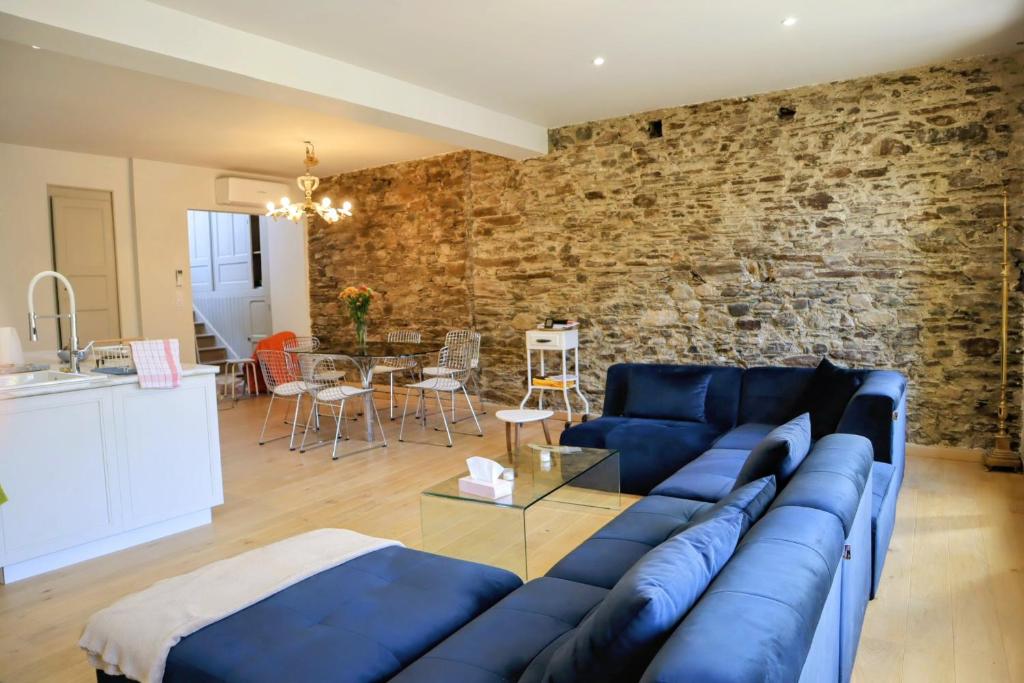 a living room with a blue couch and a brick wall at La myrtillette in Luchon