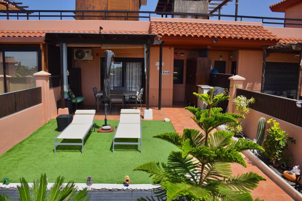 a balcony with a table and chairs on grass at Villa Zen in Majanicho