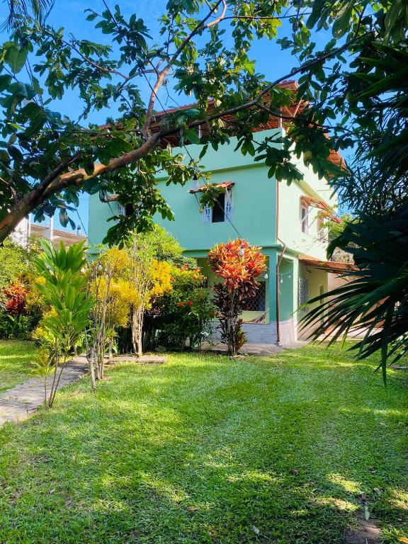 a green and white building with a yard at Casa la Bohème in Serra