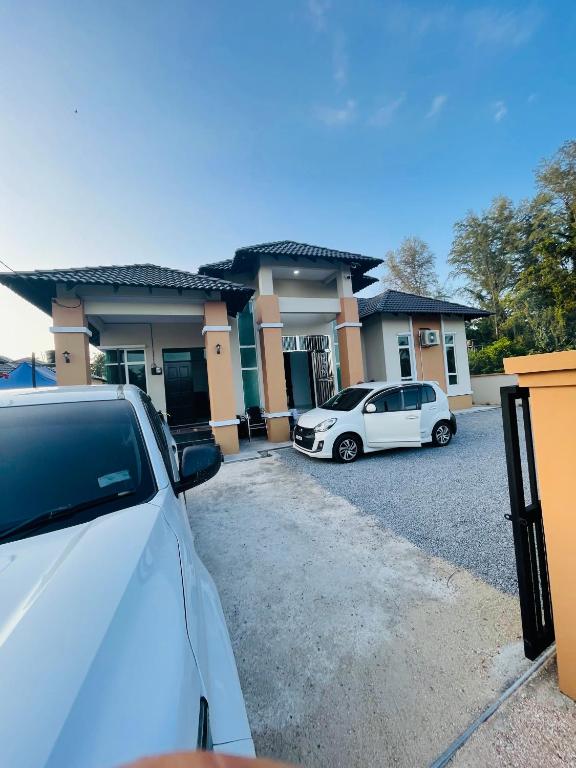 two cars parked in front of a house at D Aur Poolvilla Seaview in Bachok