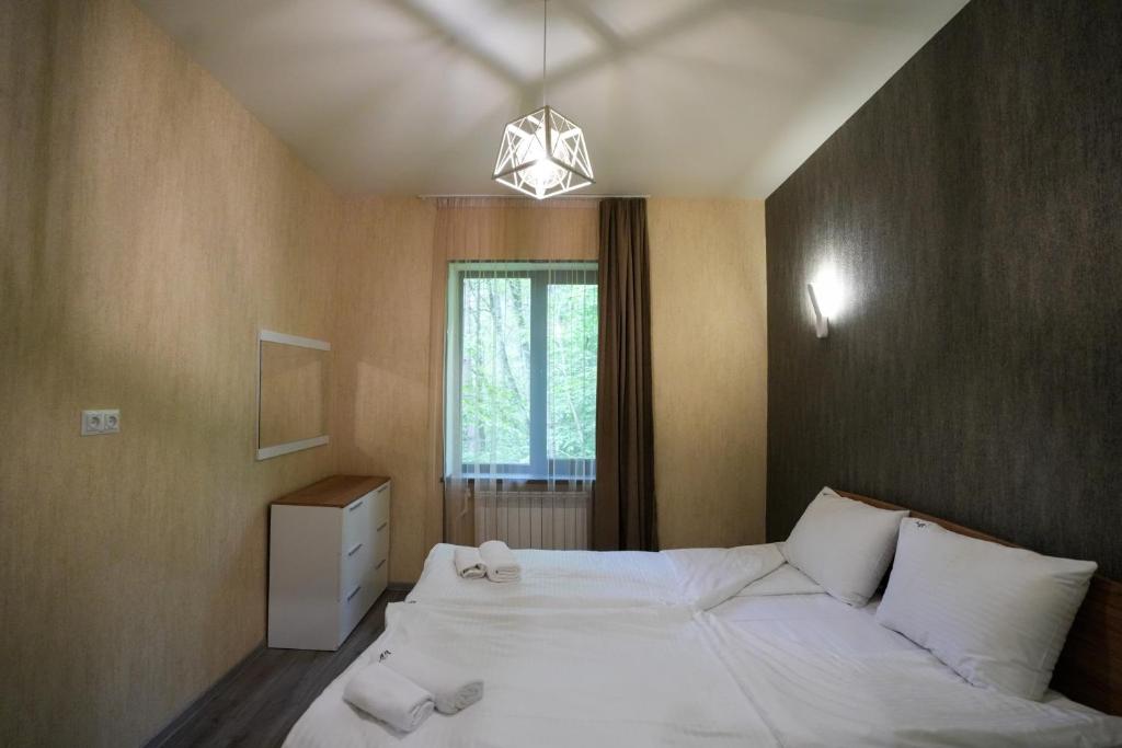 ein Schlafzimmer mit einem großen weißen Bett und einem Fenster in der Unterkunft Khaz Cottage Dilijan in Dilidschan