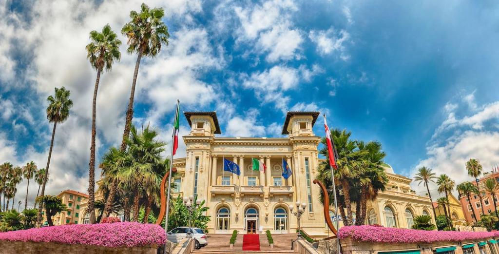 a building with palm trees in front of it at Hotel Washington in Sanremo