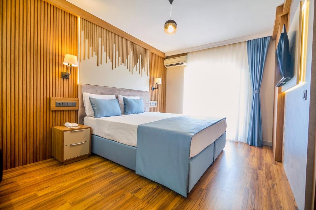 a bedroom with a large bed with blue pillows at Dalyan Caria Luxury Hotel in Dalyan