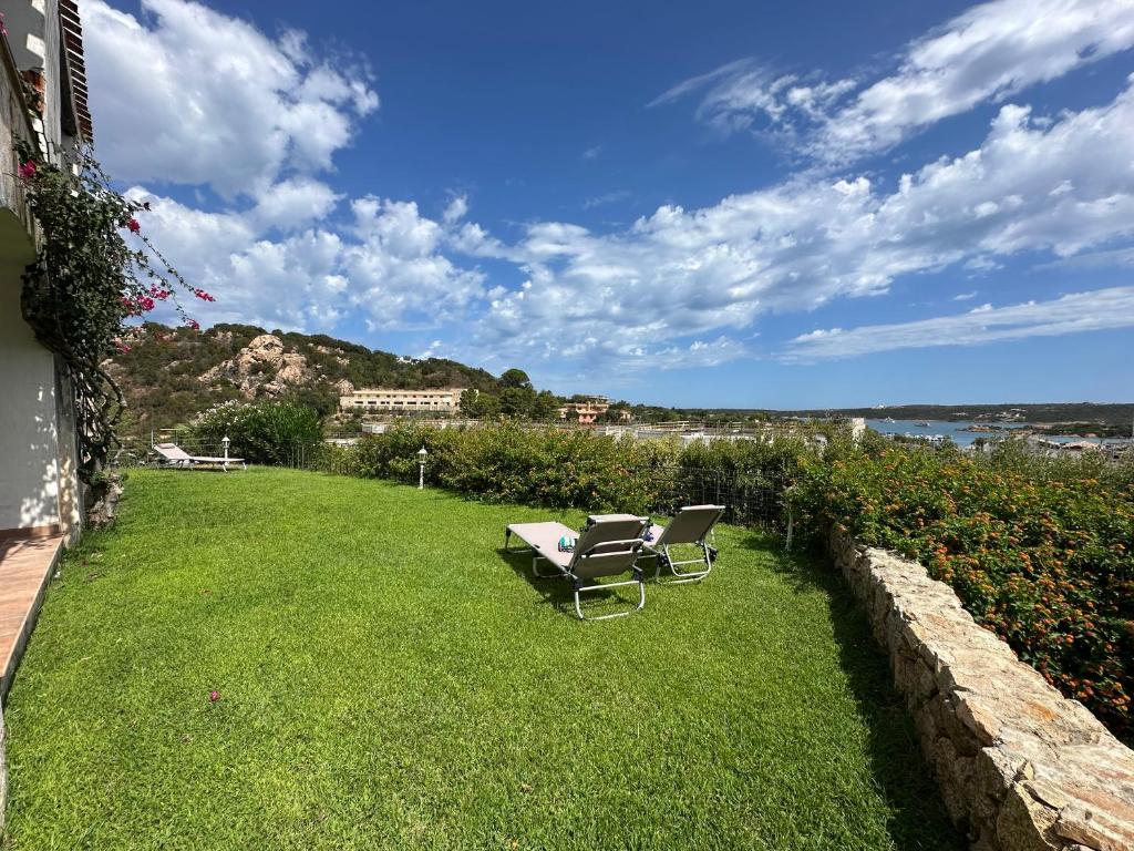 a yard with two chairs on the grass at NG Collection gli Oleandri in Liscia di Vacca