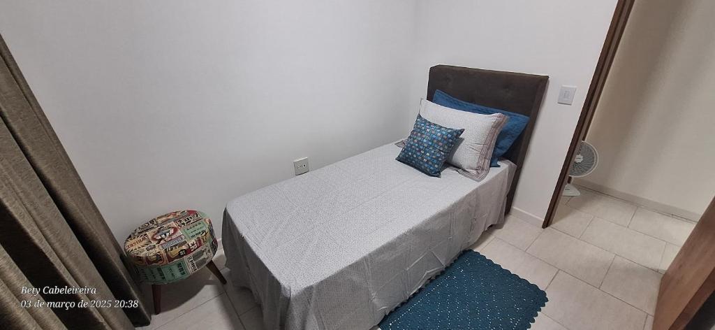a bed with pillows on it in a room at Quarto individual in Mogi das Cruzes