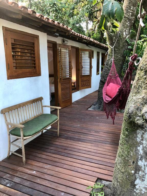 a wooden deck with a bench on a house at Suite Jenipapo Caraiva in Caraíva