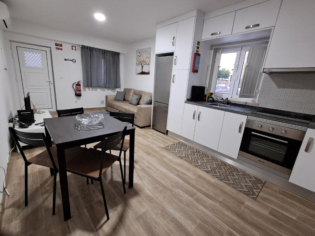 a kitchen and living room with a table and a kitchen and a couch at Casa do Sardão in Sardoal
